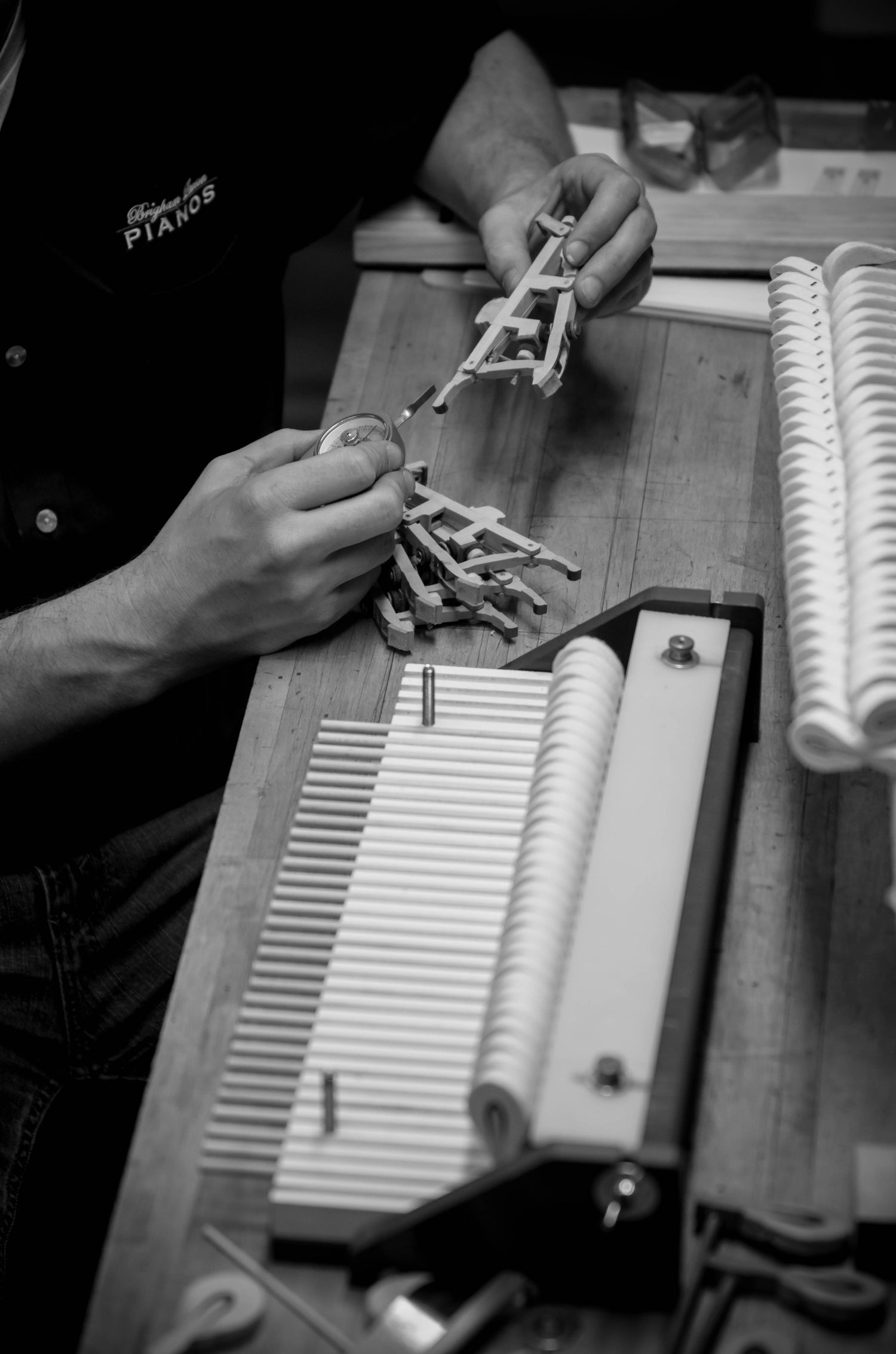 Brigham Larson restoring a piano in the family heirloom piano restoration shop, hammer action on a table.