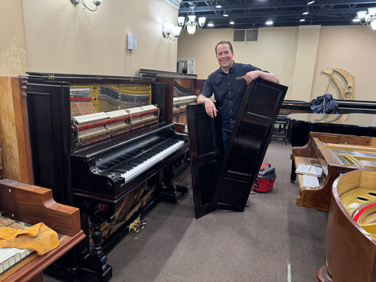 Brigham Larson in the Family Heirloom Piano Restoration Shop in Orem, UT standing by a fully rebuilt and refinished 1890 Emerson upright family heirloom piano
