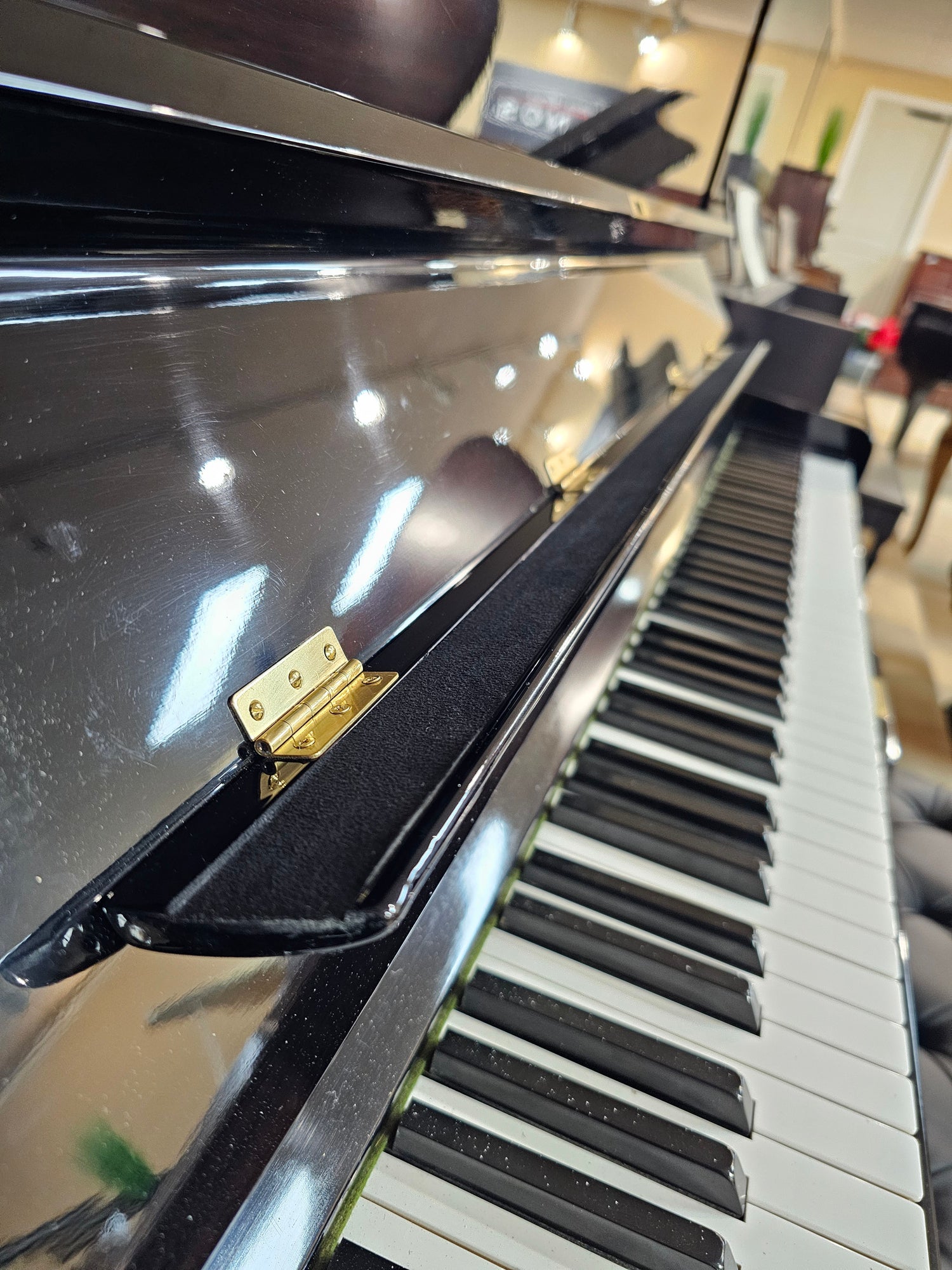Close-up of a Yamaha U3 custom music desk and piano keyboard with a focus on the keys and action mechanism.