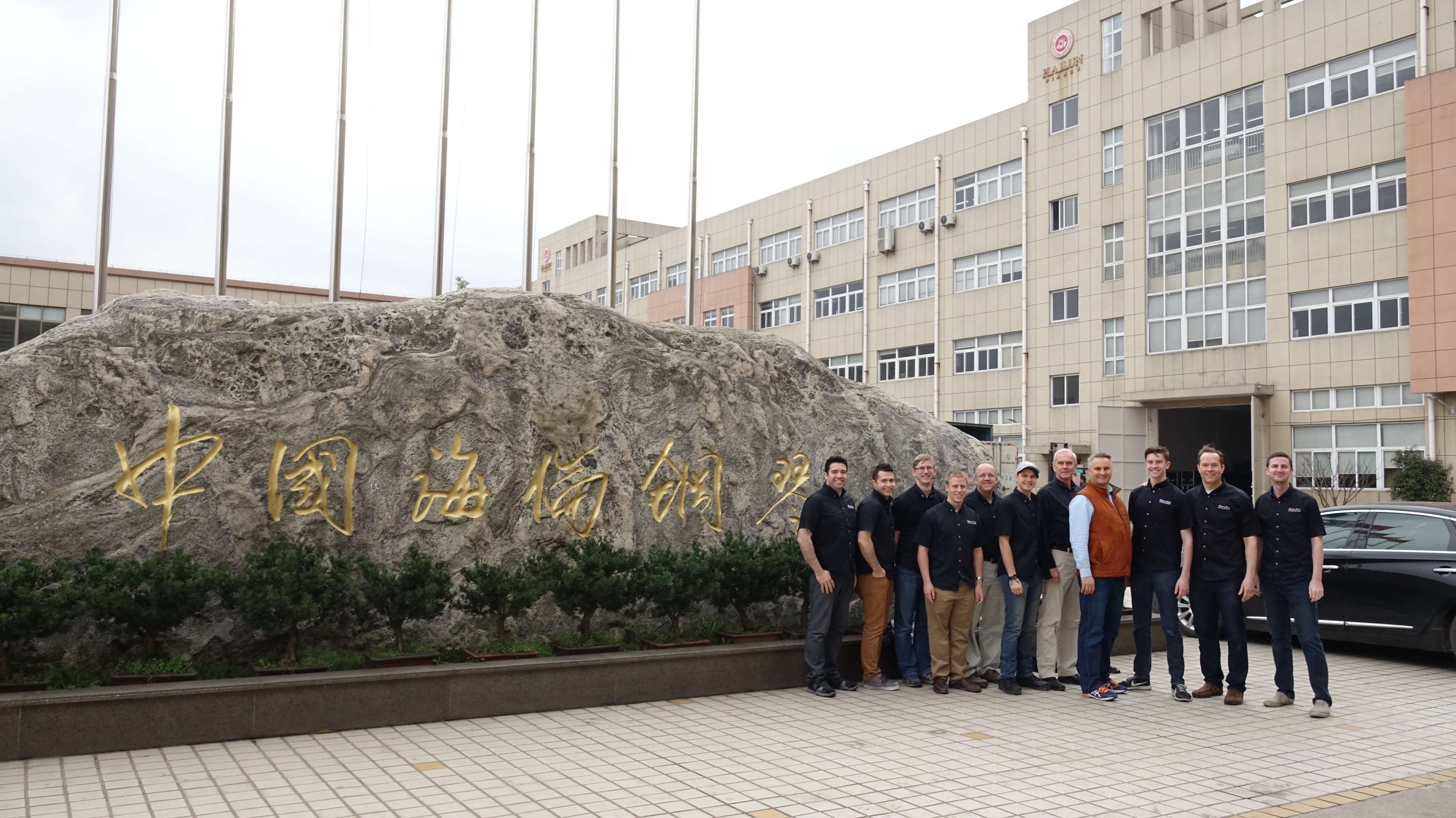 Brigham Larson and tour group standing outside the Hailun Piano Company factory building during the 2018 Hailun factory tour.