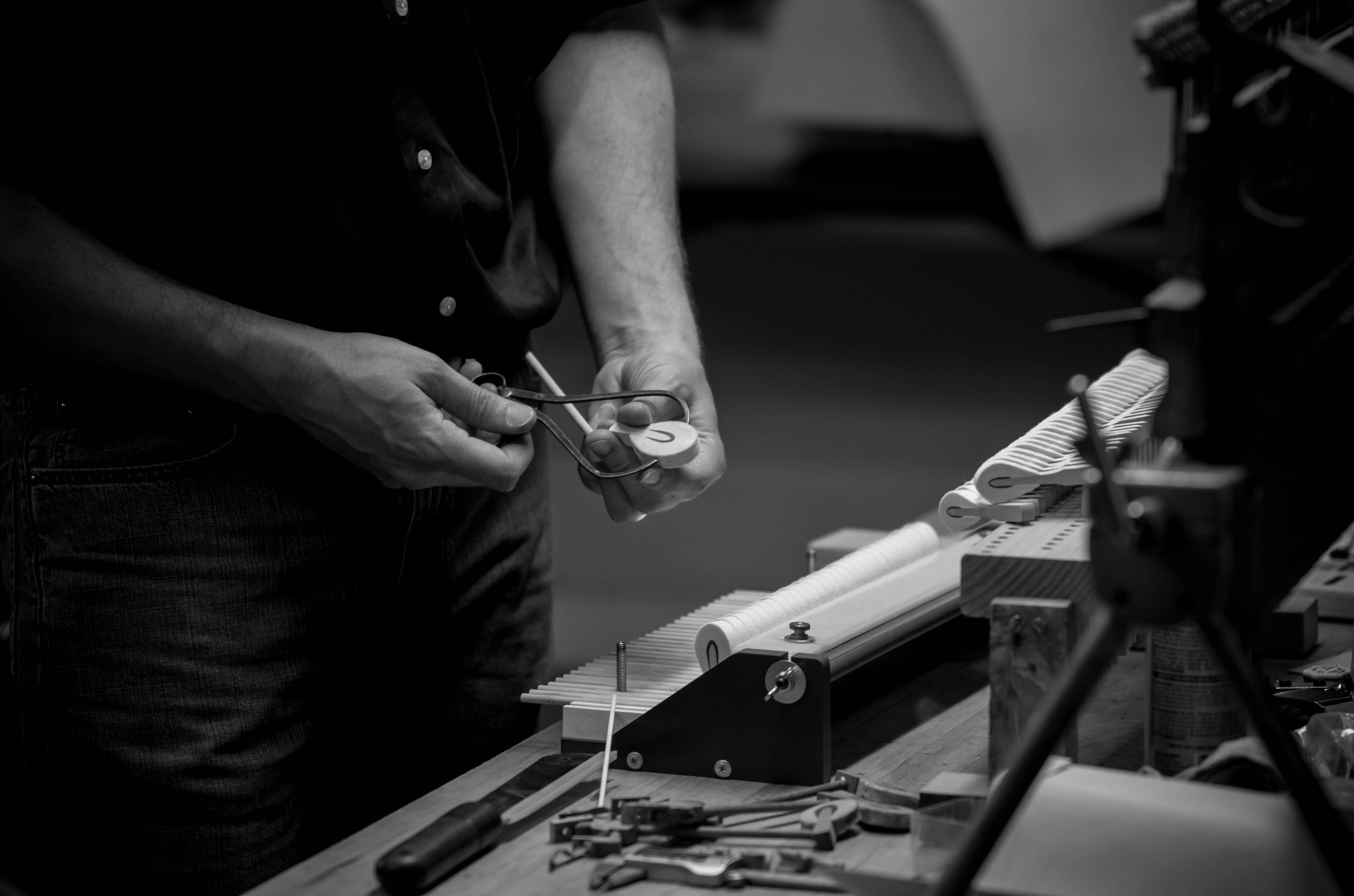 Brigham Larson in the family heirloom piano restoration shop working with piano parts