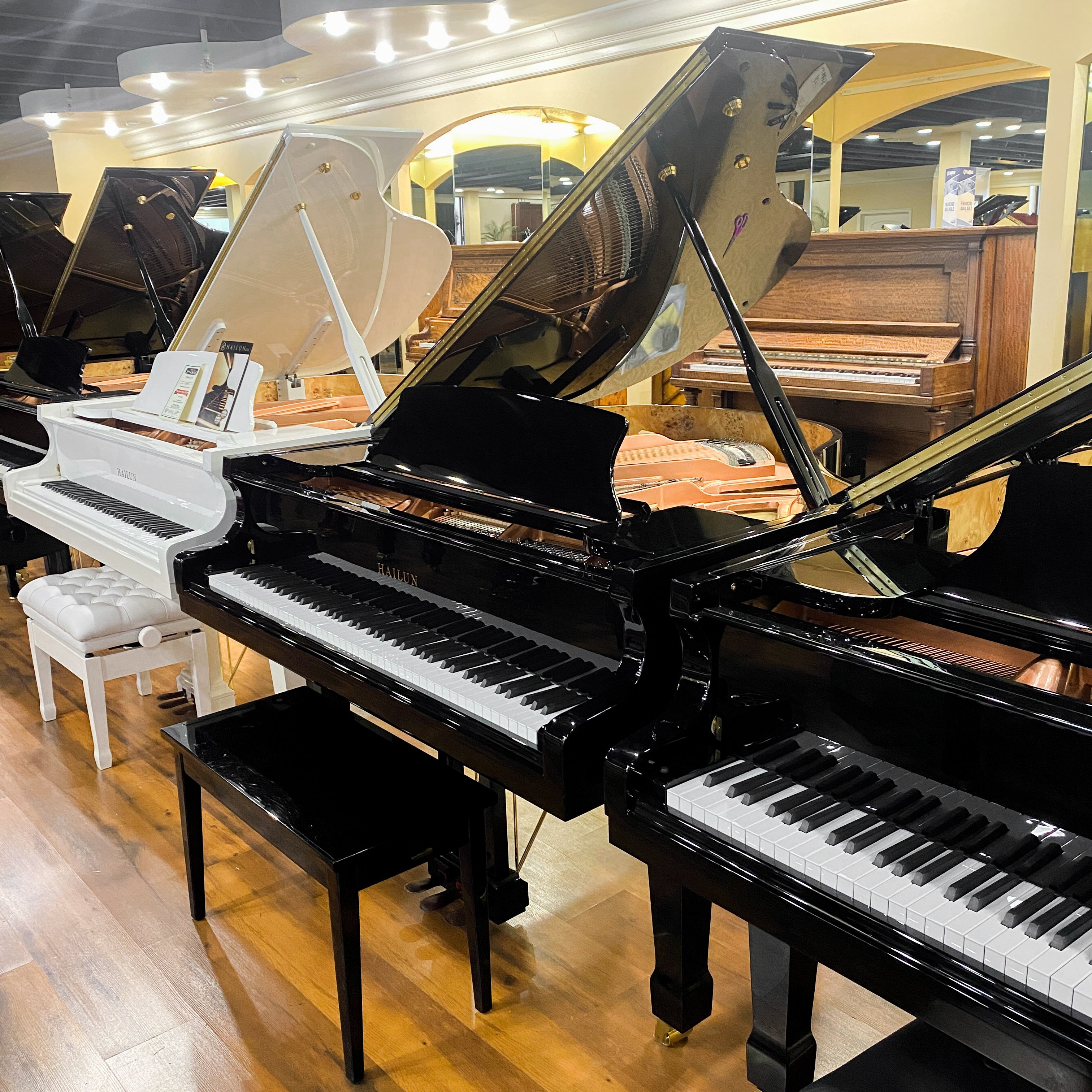 Brigham Larson Pianos showroom of grand and upright pianos for sale new and refurbished or restored pianos, beautiful lined up in rows for sale pianos.